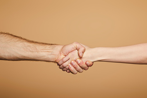 cropped view of man and woman holding hands isolated on beige