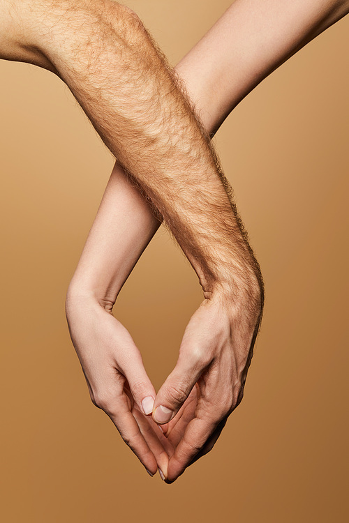 cropped view of man and woman touching hands isolated on beige