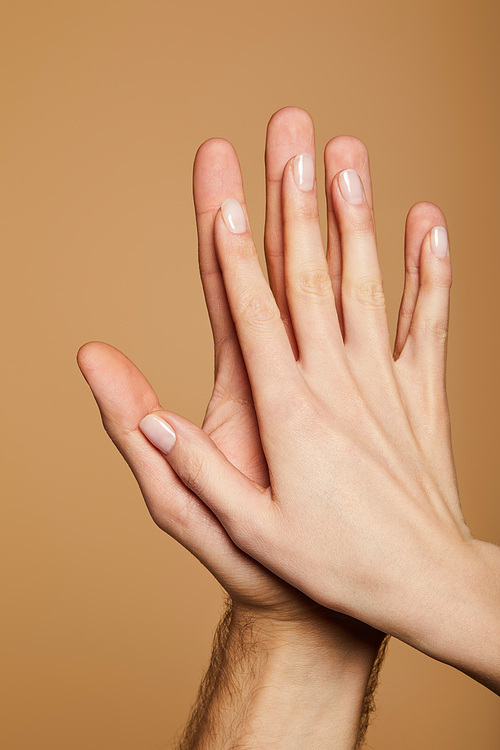 cropped view of man and woman giving high five isolated on beige