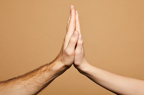 cropped view of man and woman giving high five isolated on beige