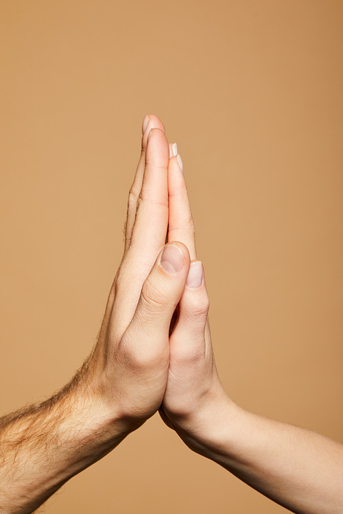 cropped view of man and woman giving high five isolated on beige