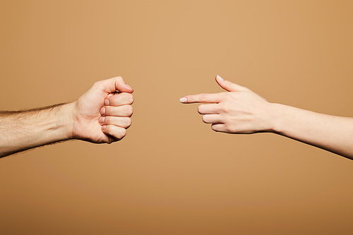 cropped view of woman pointing with finger at man fist isolated on beige