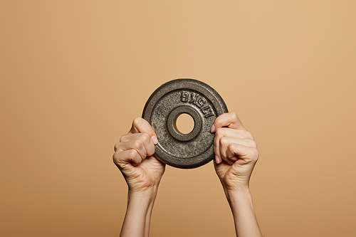 cropped view of woman holding weight isolated on beige