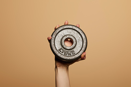 cropped view of woman holding weight isolated on beige