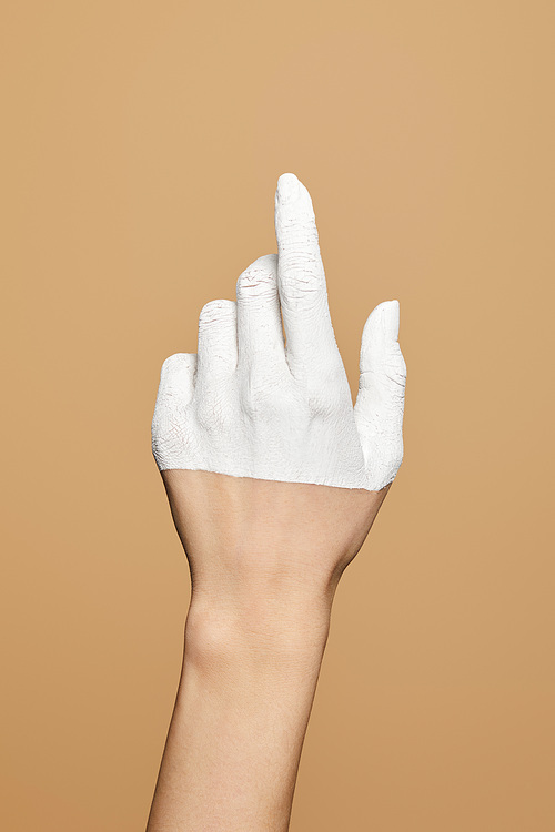 cropped view of woman with white painted hand isolated on beige