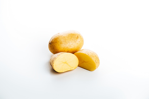 raw whole and cut fresh potatoes on white background