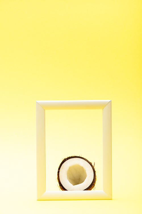 delicious sweet coconut half in square frame on yellow background