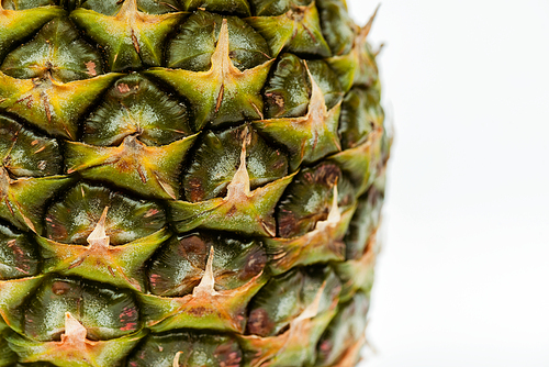 close up view of pineapple with brown textured peel isolated on white