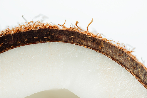 close up view of coconut half with brown textured peel isolated on white