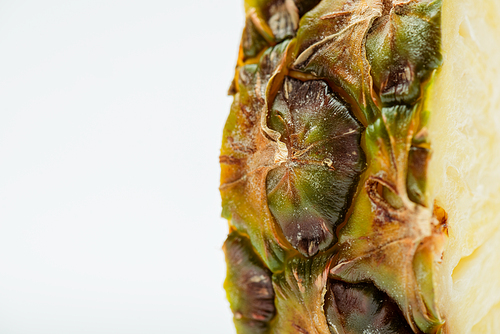 close up view of pineapple slice with brown textured peel isolated on white