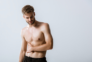 shirtless bearded man with stomach pain isolated on grey