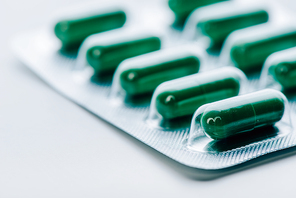 selective focus of bright and colorful pills on white background