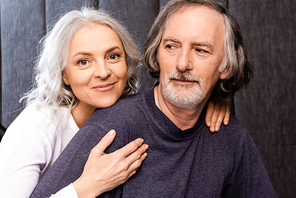 happy woman hugging bearded mature husband at home