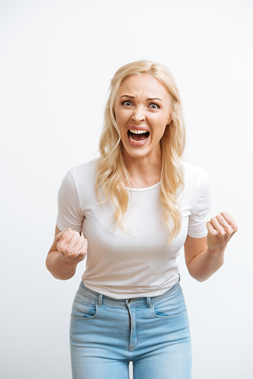 irritated woman screaming and showing fists while  isolated on white