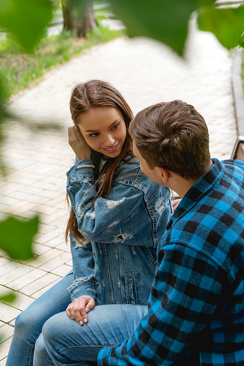 selective focus of attractive girl touching hair while flirting with boyfriend