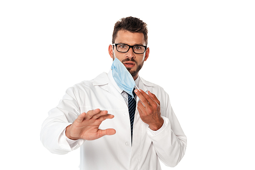 Scared doctor holding medical mask and  isolated on white