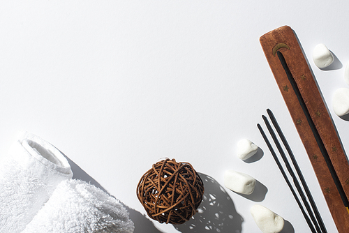 top view of aroma sticks, stones, towels and decorative ball on white background