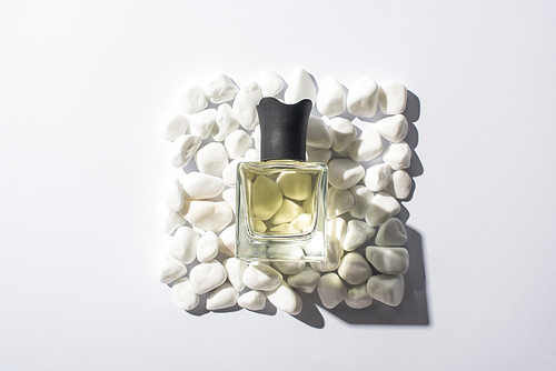 top view of home perfume in bottle on square made of stones on white background