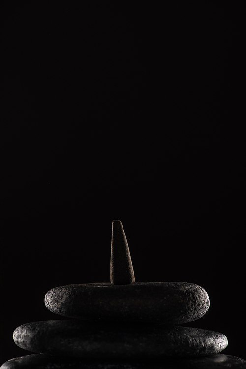 incense cone on stones isolated on black background