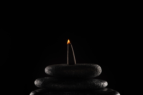 burning incense on stones isolated on black background