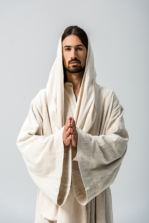 religious man with praying hands and jesus robe with hood standing isolated on grey