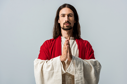 bearded man standing with praying hands isolated on grey