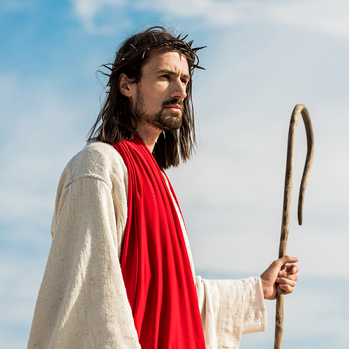 jesus in wreath holding wooden cane outside