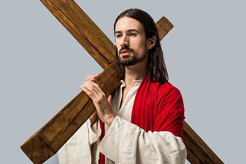 handsome bearded man in jesus robe holding wooden cross isolated on grey