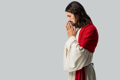 side view of man with closed eyes praying isolated on grey