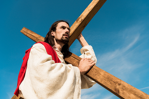 low angle view of bearded man with wooden cross