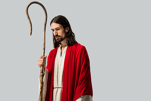 sad man in jesus robe holding wooden cane isolated on grey