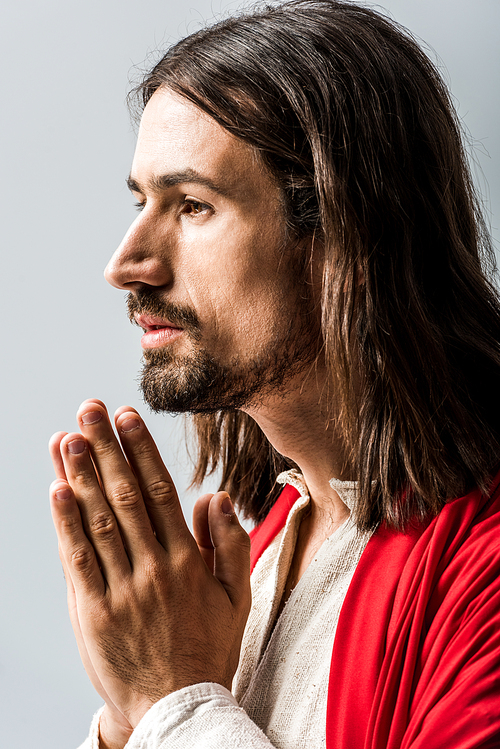 bearded and handsome man praying isolated on grey