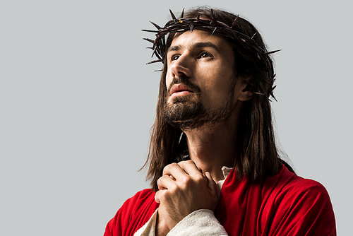 handsome bearded man in wreath praying isolated on grey