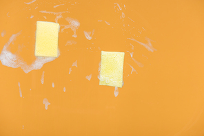 yellow sponges with foam on orange background