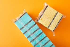 top view of packed blue and yellow sponges for house cleaning on orange