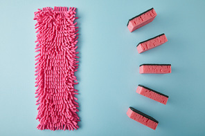 flat lay with pink rag and sponges for house cleaning on blue