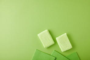 top view of sponges and rags for house cleaning on green