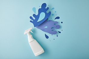 top view composition with spray bottle and blue water splashes made of paper, on blue