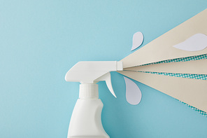 composition with cleaning spray bottle and white water drops made of paper, on blue