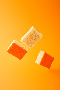 yellow falling sponges for dish washing isolated on orange