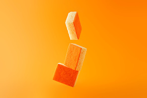 falling sponges for dish washing isolated on orange