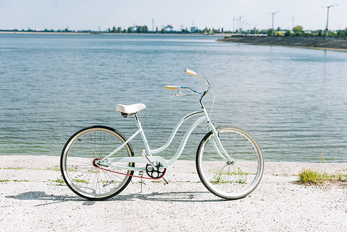 side view of bicycle near blue river in summer in sunshine