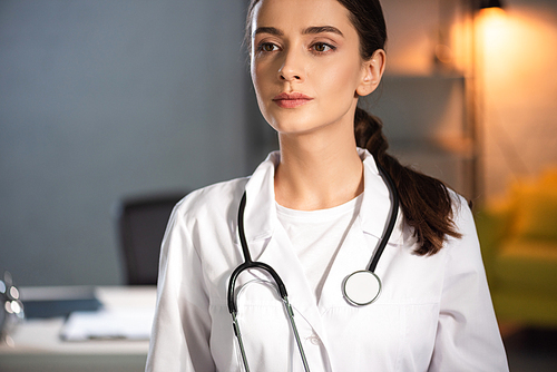 attractive doctor in white coat with stethoscope during night shift