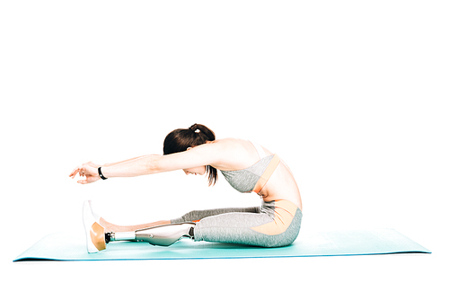 side view of disabled sportswoman with prosthesis stretching isolated on white