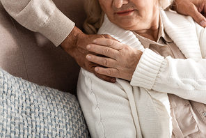 cropped view of senior woman touching hand on husband