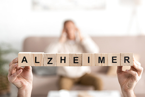cropped view of senior woman holding wooden cubes with alzheimer letters