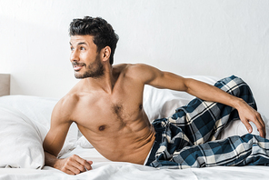 handsome and sexy bi-racial man smiling and looking away in morning