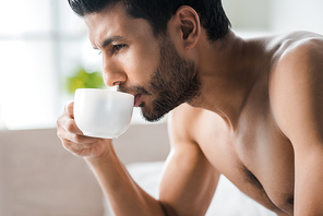 side view of handsome bi-racial man drinking coffee in morning