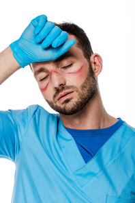 tired doctor with marks on face and closed eyes touching forehead isolated on white