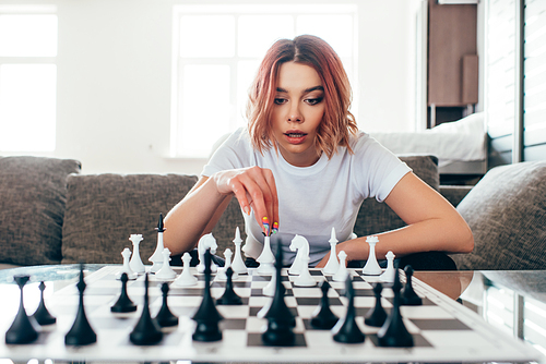 attractive girl playing chess on self isolation, selective focus